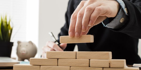 front-view-businessman-with-wooden-building-blocks