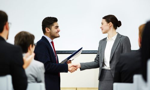 Coach congratulating one of business course attendants on graduation event